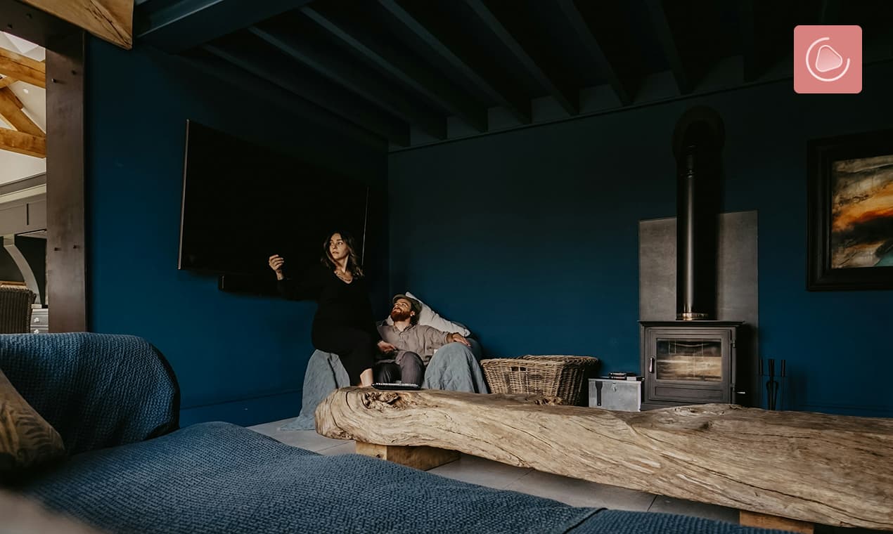 A couple sitting on the same couch, both on their phones, close but not really together